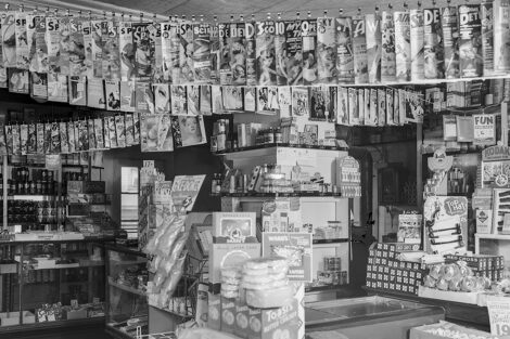Numerous pulp magazines hang from a line in this grocery store, in a photo taken in spring 1939 at an unknown location.
