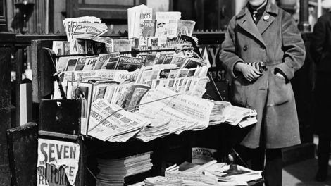 This blind news vendor has April 1926 issues of "Detective Story Magazine," "Western Story Magazine," and "Short Stories" for sale.