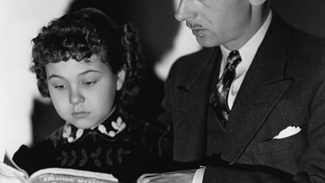 John Qualen and Jane Withers, who play father and daughter in the movie "Angel's Holiday," look over the May 16, 1936, number of "Detective Fiction Weekly" in this publicity photo.