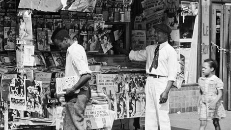 A newsstand in Harlem includes several pulps from July 1939 deep within its display, including "Horror Tales," "Ace G-Man Stories," "The Spider," "Doc Savage," "The Shadow," "Operator #5," and "Love Tales."