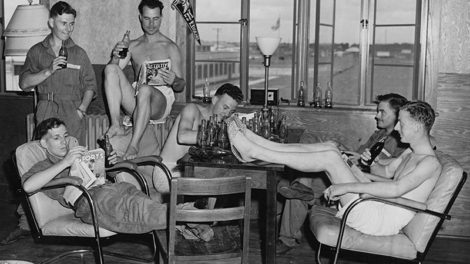 Men with the Royal Air Force Volunteer Reserve take a break from training at the Graham Aviation Co. Flying School in Americus, Ga., on July 23, 1941. One of the men reads the Spring 1941 number of "Exciting Sports," while another reads the August 1941 number of "Spicy Detective" with part of its cover carefully obscured.