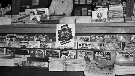 This newsstand has for sale a number of November and winter 1942 issues of pulps along its lower shelves: "Exciting Storts," "Exciting Mystery," "Fight Stories," "Detective Story," "The Shadow," "Short Stories," "West" and more.