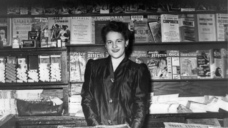 A young woman stands in a news stand in early 1943. In the upper left is the type-heavy cover of "Unknown Worlds" (February 1943), as is part of the cover of "Astounding Science-Fiction" (March 1943).