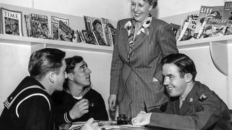 Behind the woman and the servicemen, there are two stacks of pulps. The stack on the left is topped with the October 1943 number of "Western Short Stories"; the stack just behind the woman's right shoulder is topped with the Sept. 18, 1943, number of "Street & Smith's Western Story Magazine."