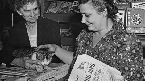 The caption for this photo, dated Aug. 24, 1945, identifies Genie Pittsley, left, as the clerk at C&S Newsstand in Painesville, Ohio, and Mary Kamenar as a customer. (Kamenar is holding an Aug. 17, 1945, issue of "The Cleveland Press.") Just over their shoulders are a number of September and October 1945 pulps, and to their right Penguin paperback books.