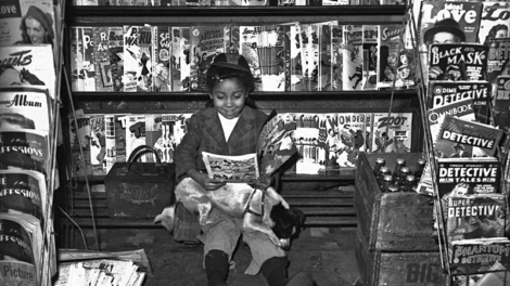 A young girl in Pittsburgh, Pa., reads a comic book, while pulps from March 1947 await sale on a rack nearby.