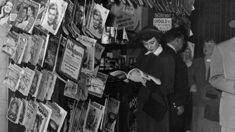 Actress Betsy Drake poses at a so-called "newsstand" in this Warner Bros. publicity photo. It's sometime after 1949, since there is a "New Yorker" cover dated July 1949. Otherwise, this stand is chock-a-block with magazines, both real and fictitious, from a variety of dates — but no pulps. There is a neat poster for The Shadow at the top.