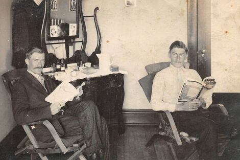 Two fellows relax by reading magazines, including the "Blue Book" (January 1914) on the right.