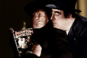 Actors reading a copy of "The Phantom Detective" pulp magazine