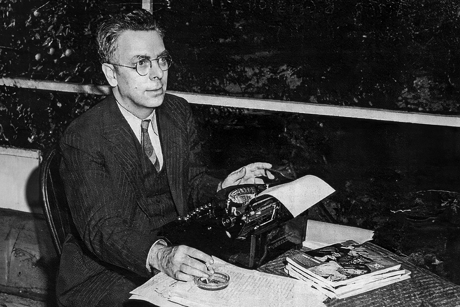 Walter Gibson posing with his typewriter and a stack of The Shadow pulp magazines sometime around 1941.