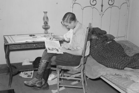 A boy reads "Fight It Out," by Oscar Schisgall, in the September 1937 number of Five Star Western Novelets, at the home of A.O. Ryland near Williston, N.D., in October 1937.